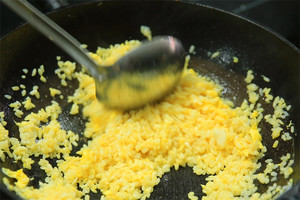 大火加熱炒鍋，再入油，燒到四至五成熱時倒入雞蛋液，在未凝結(jié)之前，加米飯煸炒，不停翻炒并用鍋鏟將成塊的米飯碾開、撥散。