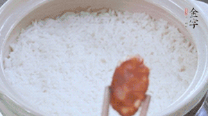 煮開后轉(zhuǎn)小火，當(dāng)米飯出現(xiàn)小孔時(shí)，鋪上金字麻辣香腸。