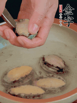 鮑魚加鹽、清水浸泡，用勺子挖出鮑魚肉。