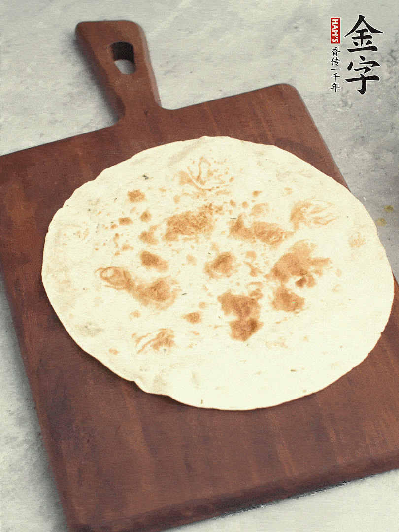 食材依次鋪在卷餅皮上，卷起來(lái)。