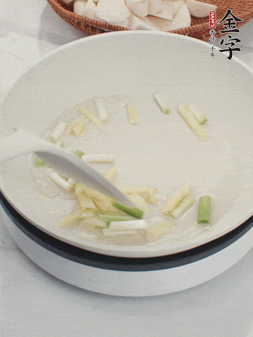 鍋中油五成熱，下蔥白、姜片爆香。