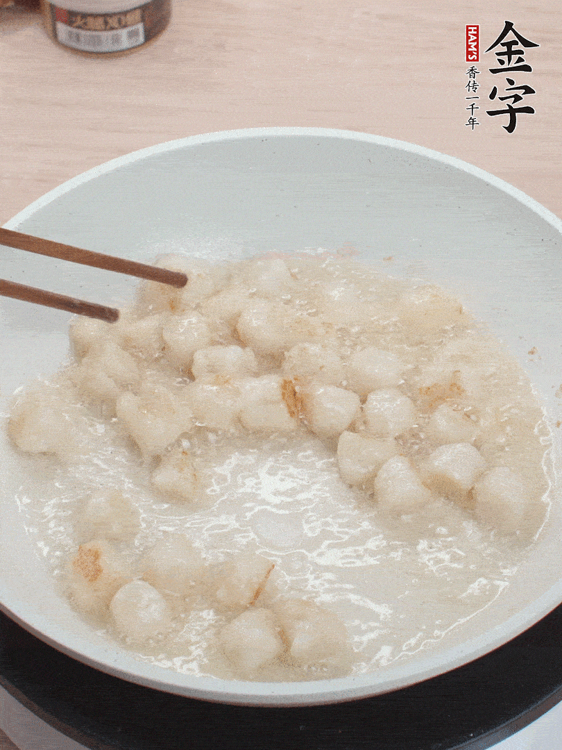 油溫4成熱，鮮貝蘸干淀粉下鍋煎，一面微黃后翻面。