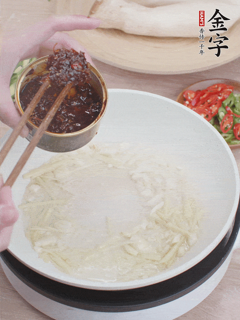 起鍋熱油，姜蒜、金字火腿干貝醬煸香。