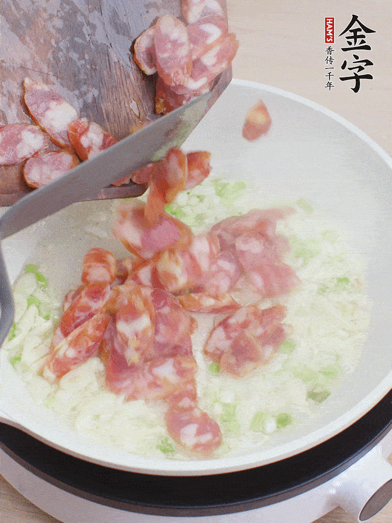 油5成熱，蒜末、蔥白爆香，下香腸炒出香味。