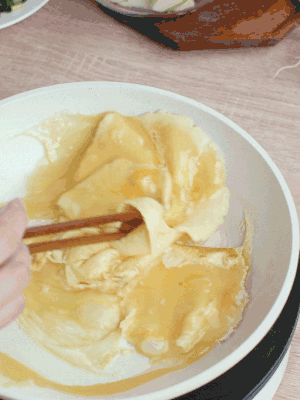 油6成熱時，下雞蛋液，邊緣凝固時翻拌成塊狀。