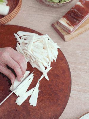 茭白切細(xì)絲，鹽水中浸泡防止氧化。