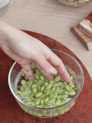 青豆剝殼，搓去外衣。