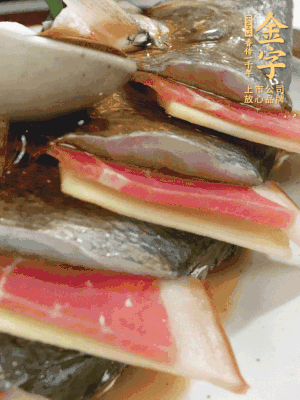 魚肚中塞蔥結(jié)、火腿片，魚身上碼放姜片、火腿片，倒入混合的料汁。