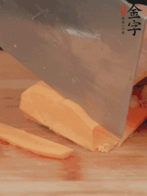 南瓜改刀切片，把蒸好的火腿鋪到南瓜上。