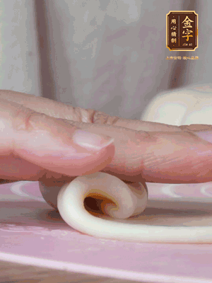 做面劑 油皮按扁，中間包入一個油酥，邊緣收緊捏死。包好的面劑按扁，用搟面杖搟壓成橢圓形。從底部向上卷成筒狀，用保鮮膜蓋好松弛15分鐘，再把筒狀縱向搟壓成長條狀。再卷一次，松弛20分鐘