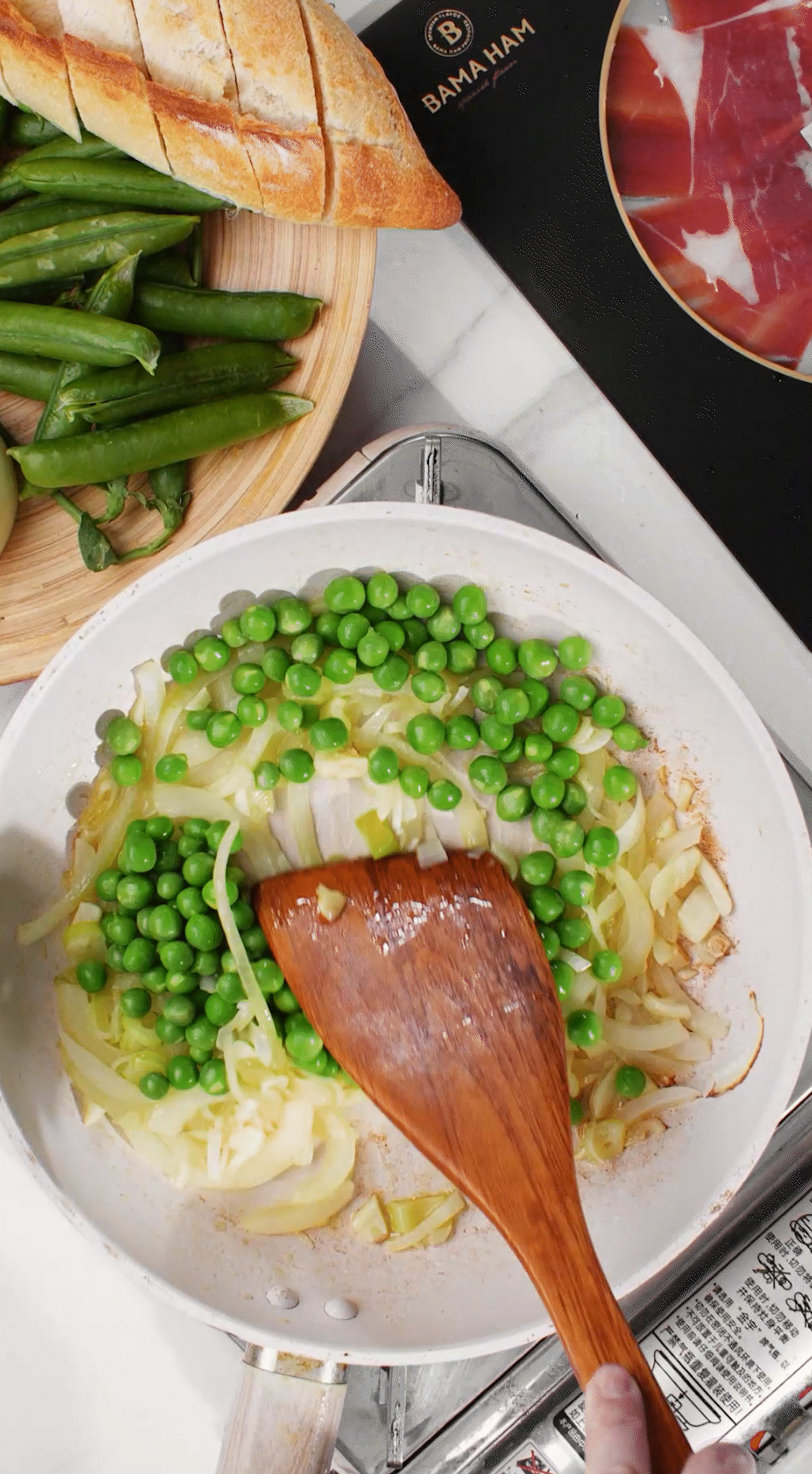 鍋中放入黃油融化，加入洋蔥絲、大蔥蔥白絲、蒜末翻炒變軟出香味。加入剛剛汆燙冰鎮(zhèn)后的豌豆，取出一點(diǎn)點(diǎn)待會(huì)擺盤(pán)裝飾用。加一點(diǎn)鹽 (和黑胡椒) 調(diào)味。